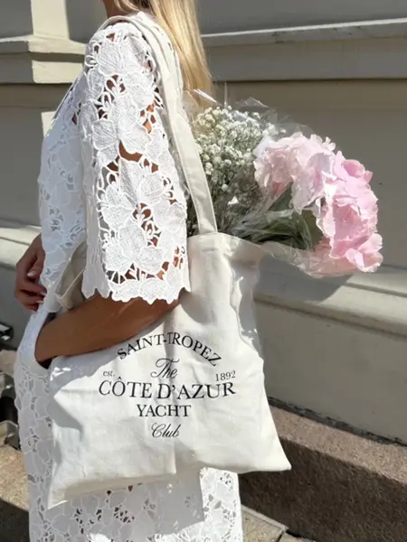 dame i hvit kjole, handlenett med blomster