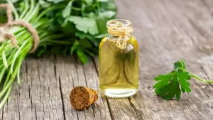 Flaste med olje på et bord sammen med urter