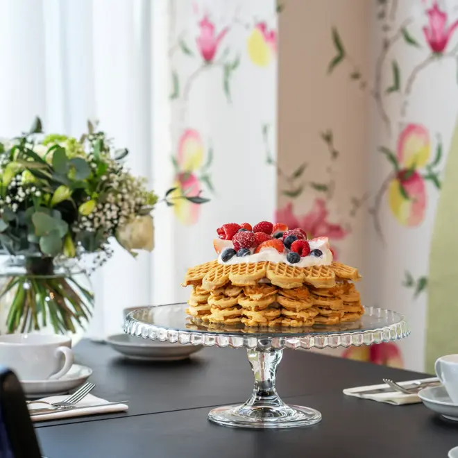 Vaffel med bær og is, spisebord, grønn sofa, blå stol, servise