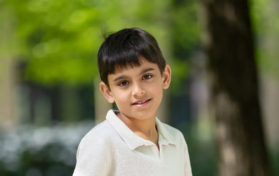 Gutt i hvit piquetskjorte og blå bukse