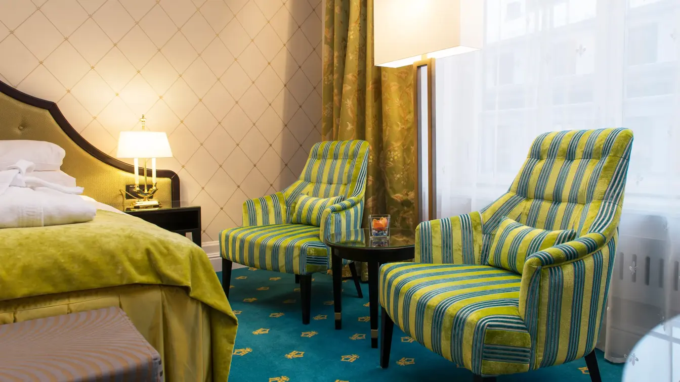Dobbeltseng og to gode lenestoler på Hotel Bristol i Oslo sentrum