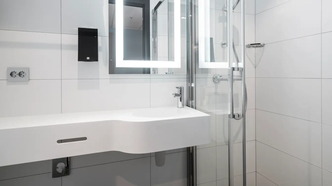 Detaljbilde av vask, speil og dusj på standard dobbeltrom