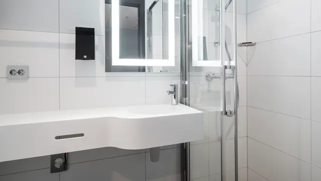 Detaljbilde av vask, speil og dusj på standard dobbeltrom