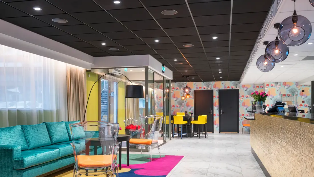 Lobby med sofa, stoler og fargerike tepper på Thon Hotel Tønsberg Brygge