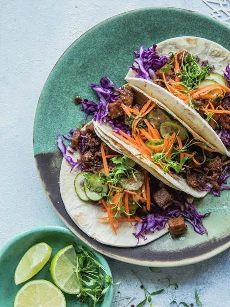 Taco på en tallerken og lime i en skål