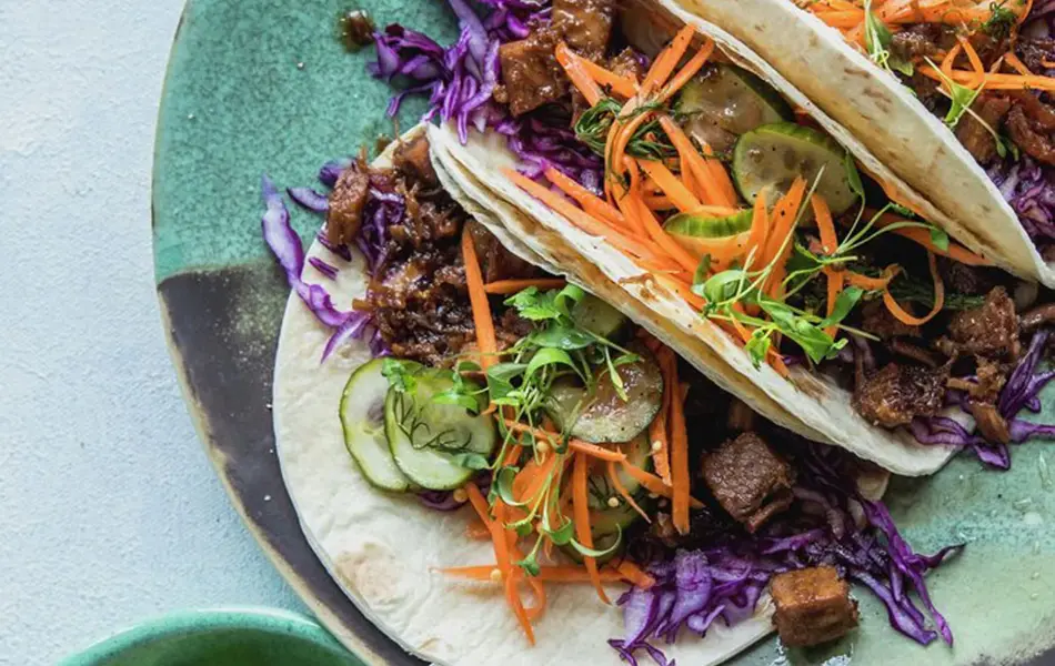 Taco på en tallerken og lime i en skål