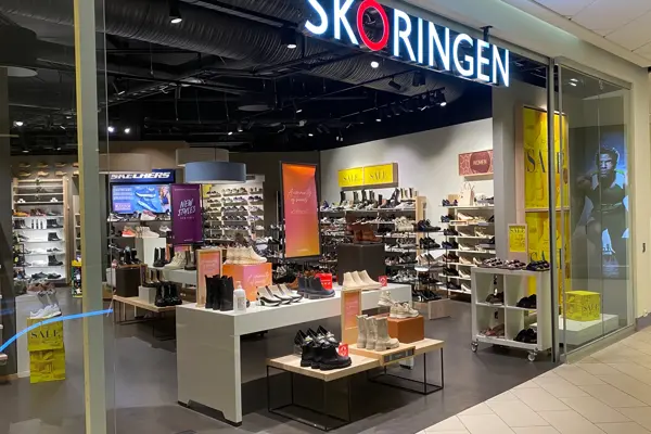 innendørs butikk med sko og hyller og skilt