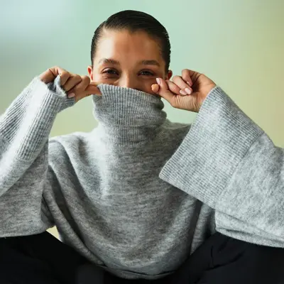 dame med grå genser og sort bukse