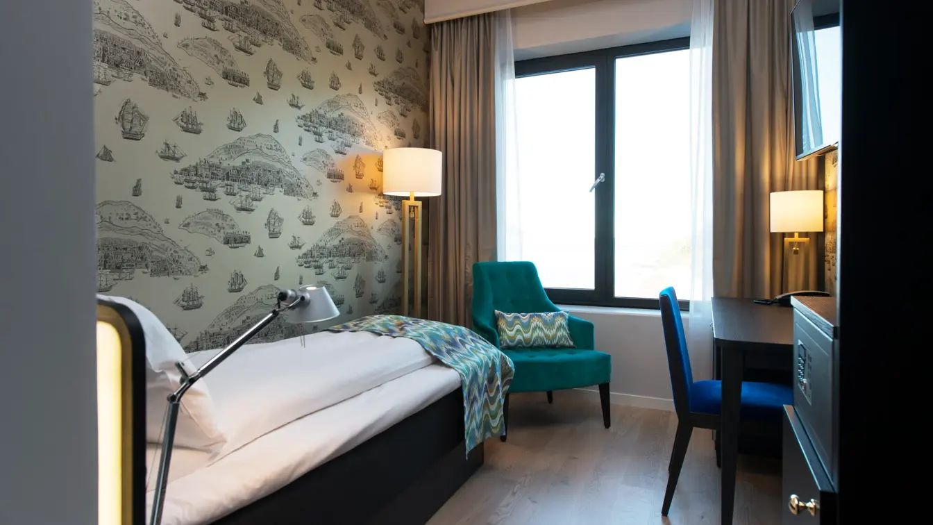Enkeltseng, stol og arbeidspult på enkeltrom på Thon Hotel Fosnavåg
