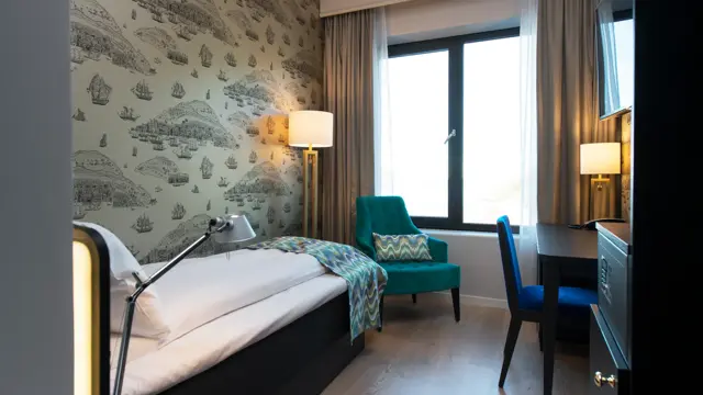 Enkeltseng, stol og arbeidspult på enkeltrom på Thon Hotel Fosnavåg
