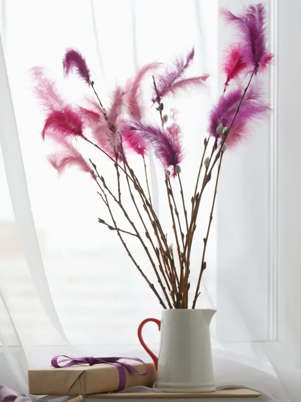 Fastelavnsris decorated with feathres and Fastelavn gifts on a window sill