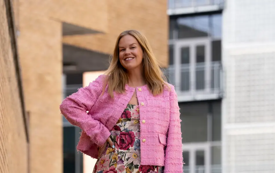Dame med blomstrete lang kjole og rosa kort jakke
