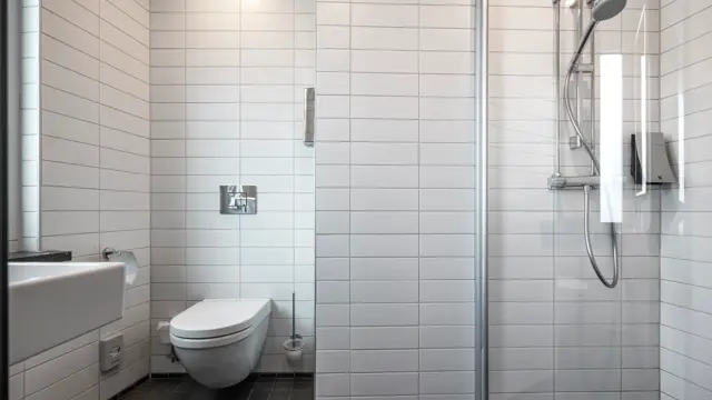 Bad med dusj og vegghengt toalett.