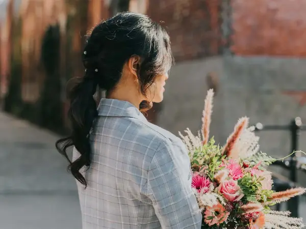Dame med hestehale og holder en blomsterbukett