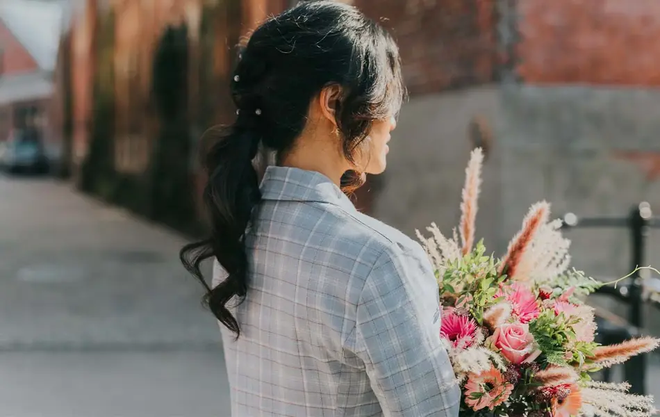 Dame med hestehale og holder en blomsterbukett
