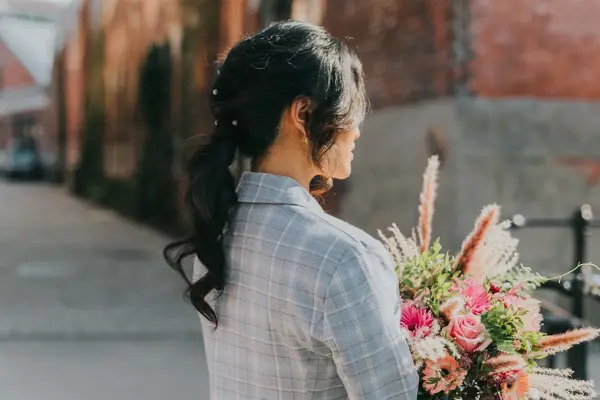 Dame med hestehale og holder en blomsterbukett