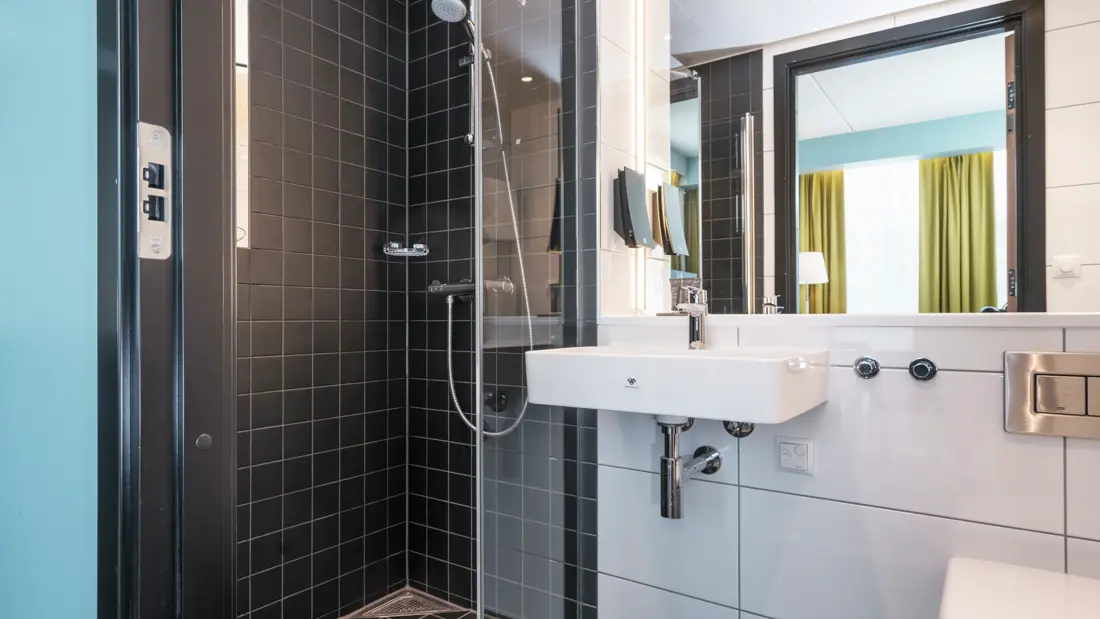 Bad med dusj og vask. Dør åpen