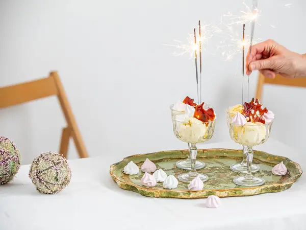 Langbord dekker til gjester med rosa servietter og grønn naturlig dekorasjon