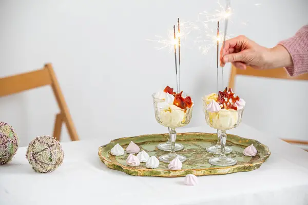 Langbord dekker til gjester med rosa servietter og grønn naturlig dekorasjon