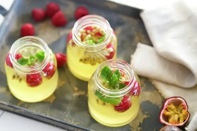 Glass med sommerdrikk som inneholder pasjonsfrukt