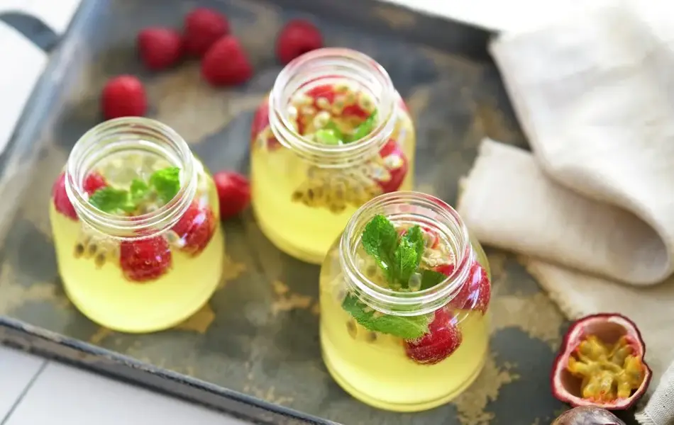 Glass med sommerdrikk som inneholder pasjonsfrukt