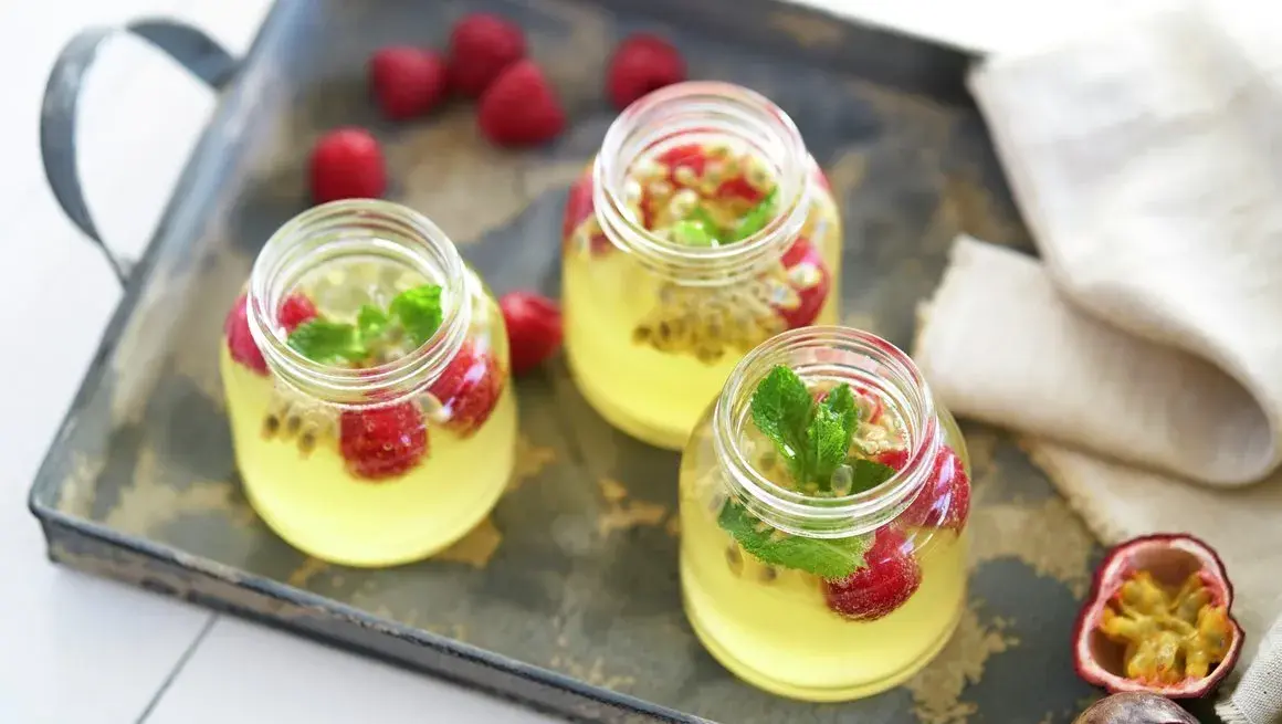 Glass med sommerdrikk som inneholder pasjonsfrukt