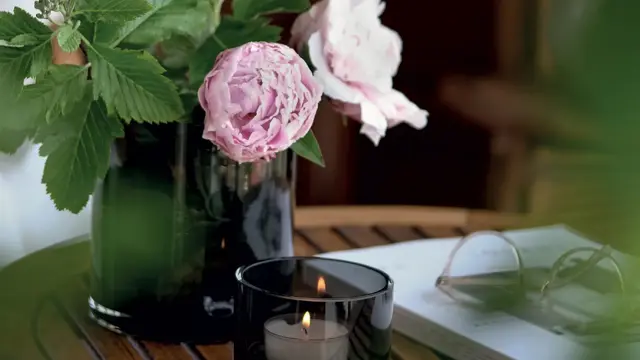 calidi lyslykt som står på et lite bord med levende lys