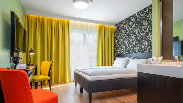 Stol, skrivebord, TV, dobbeltseng og vask i dobbelt rom på Thon Hotel Gyldenløve i Oslo