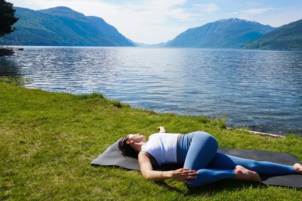 anny johansen viser yogaøvelser foran vakker fjord