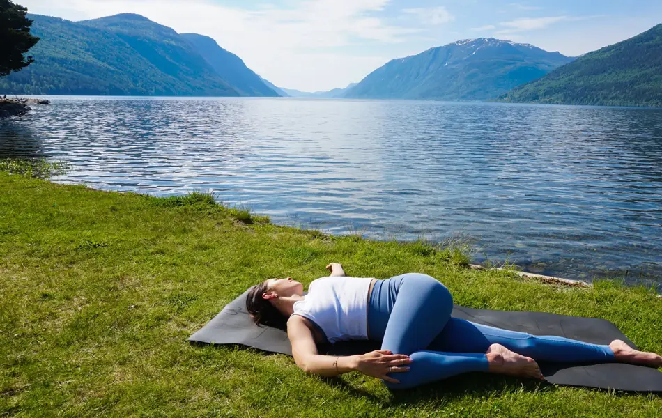 anny johansen viser yogaøvelser foran vakker fjord