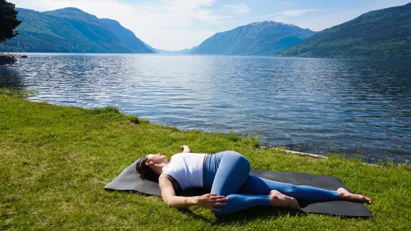 anny johansen viser yogaøvelser foran vakker fjord