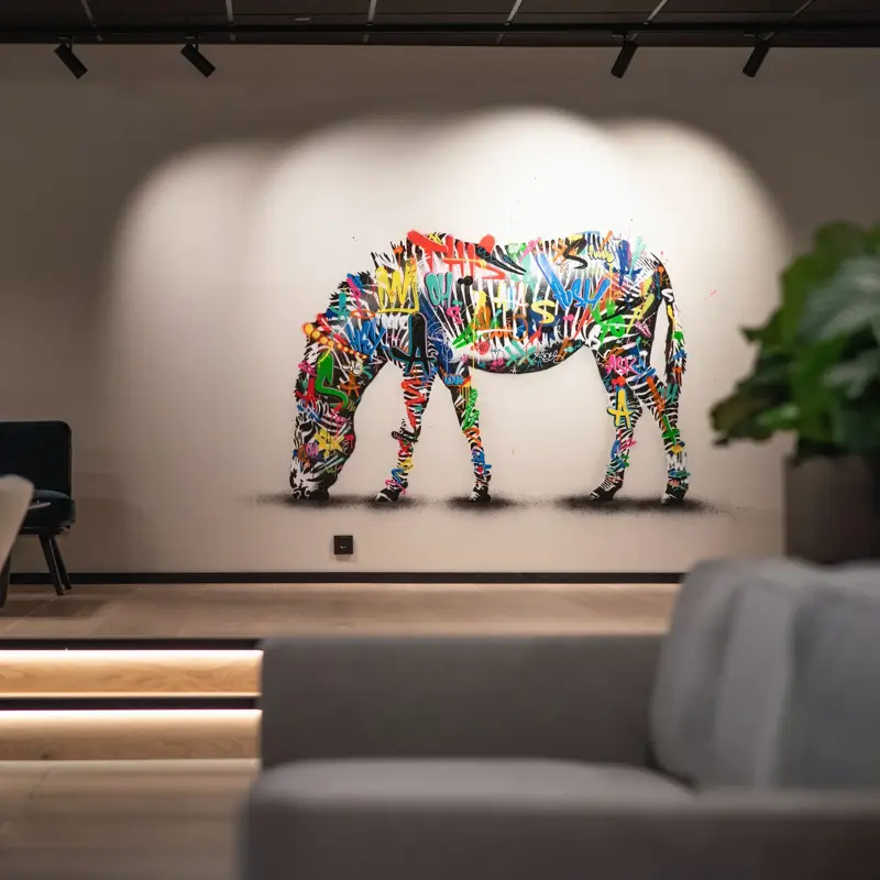 Fargerik sebra malt på hvit vegg i lobbyen på Thon Hotel Norge i Kristiansand.