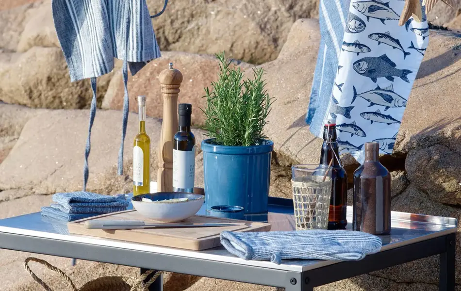 Utekjøkken med kjøkkenhåndkle, kluter, olje, krydder og skjærefjøl