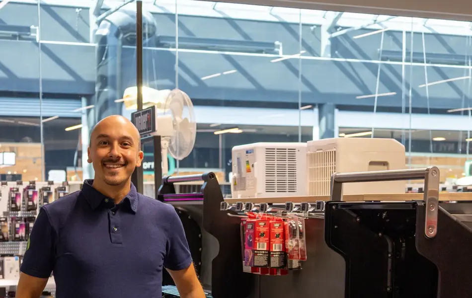 mann står ved grill i butikk