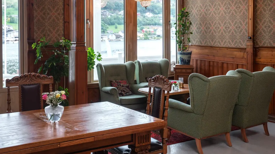 4 grønne lenestoler, salongbord, vindu, spisebord, spisestoler