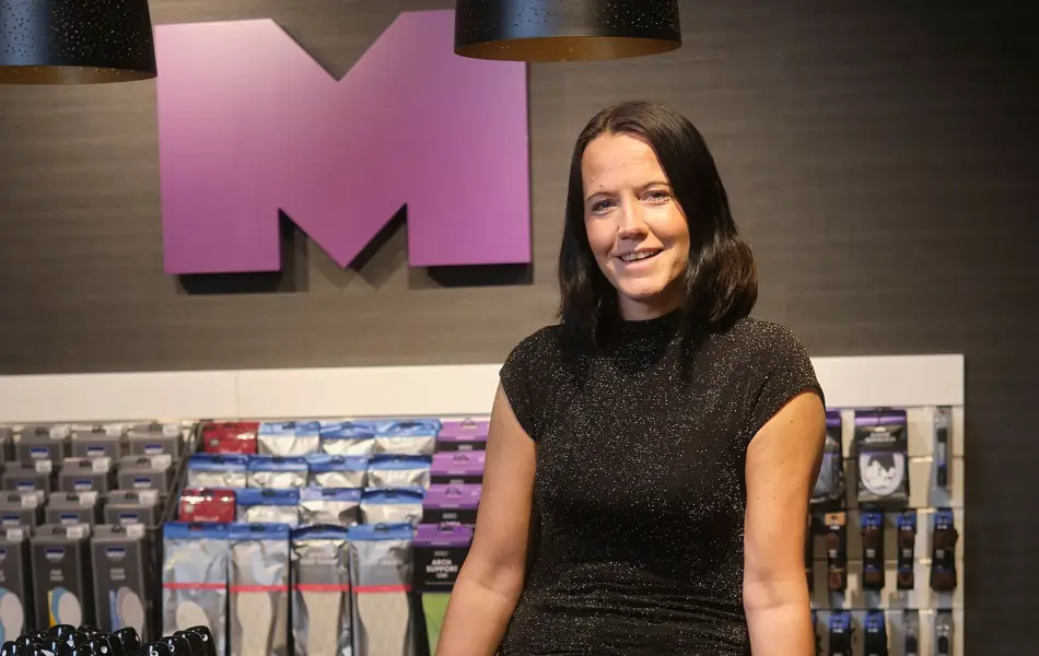 ansatt hos mani viser frem fine sko