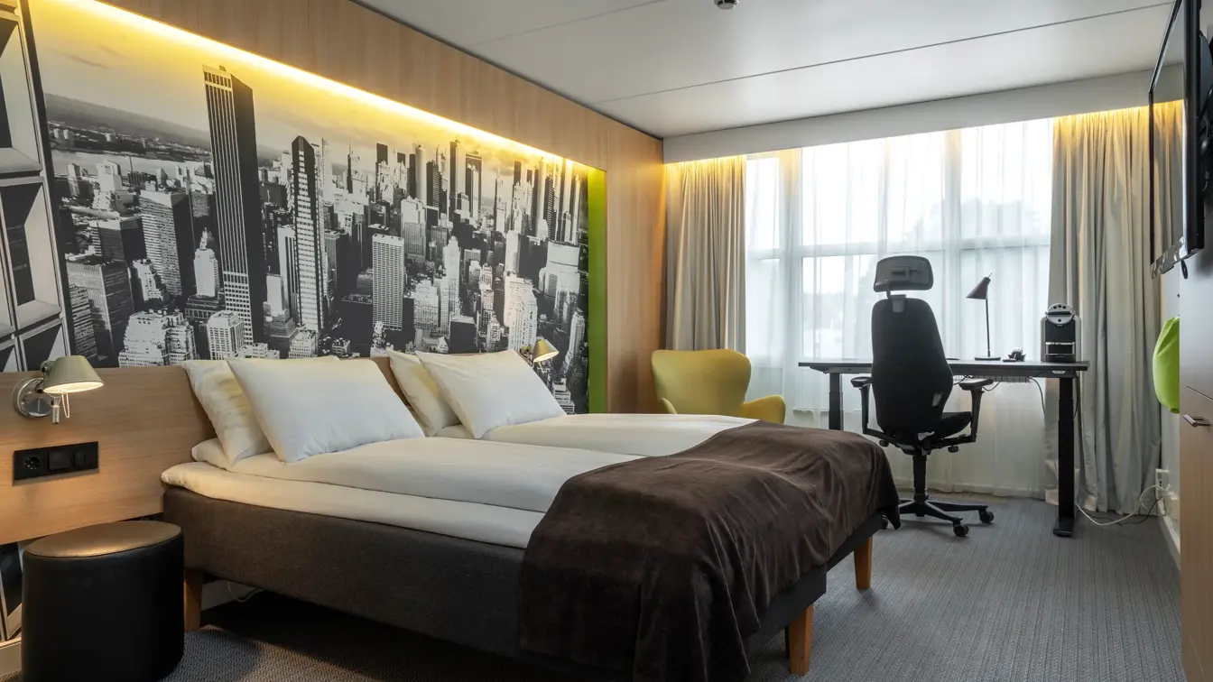 Dobbeltseng, vindu, skrivebord, skrivebordstol, TV, beige gardiner