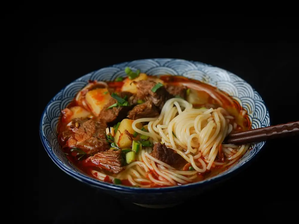 en bolle med ramen nudler, kjøtt og grønnsaker med et sett spisepinner