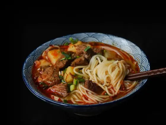 en bolle med ramen nudler, kjøtt og grønnsaker med et sett spisepinner