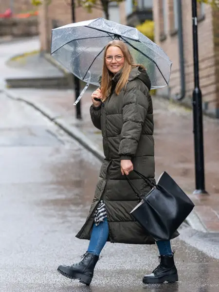 kvinne som krysser veien med paraply