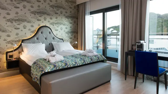 Dobbeltseng og arbeidspult på businessrom på Thon Hotel Fosnavåg med utsikt utover havet