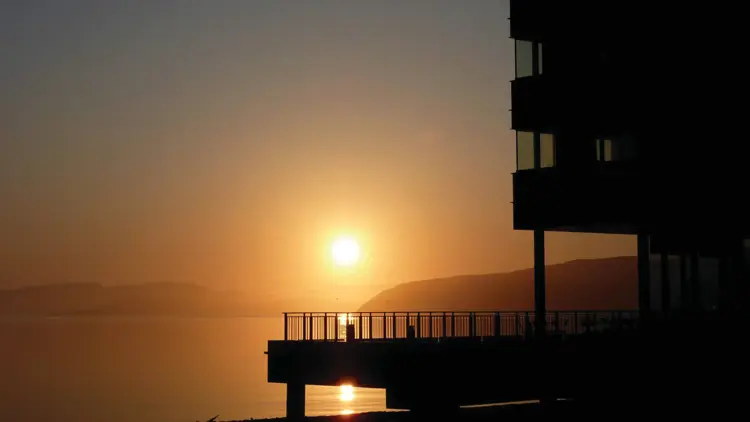 Utsikt mot havet på vinteren  med Midnattsol på Thon Hotel Kirkenes, som ligger på kaia i Kirkenes sentrum