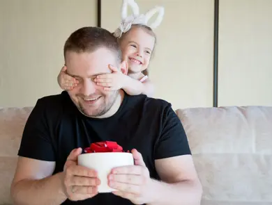 liten jente som holder for øynene på pappaen sin