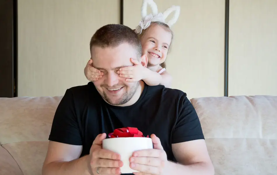 liten jente som holder for øynene på pappaen sin