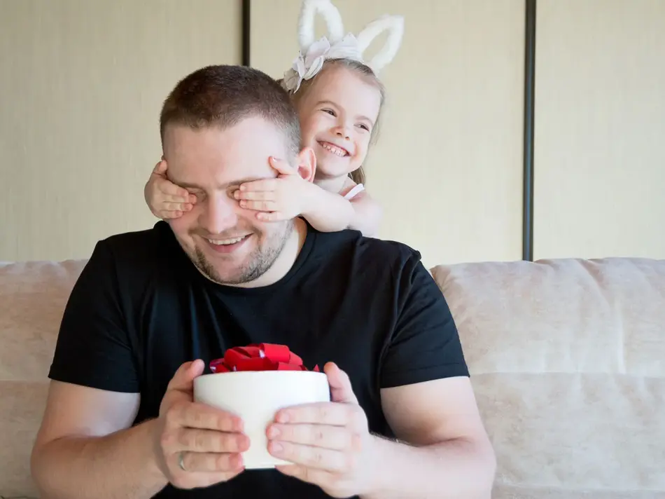 liten jente som holder for øynene på pappaen sin