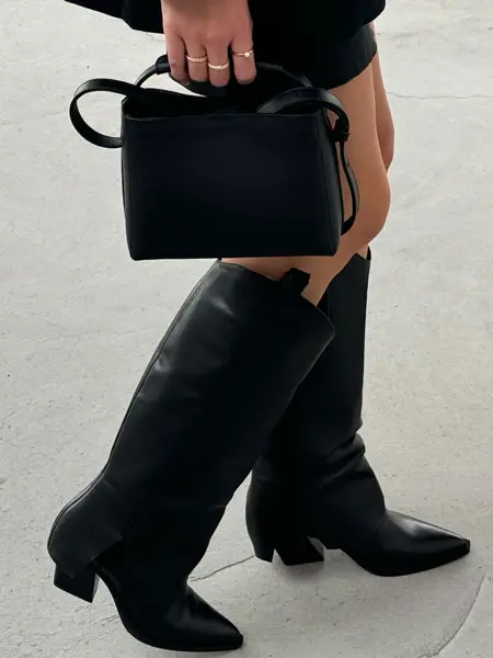 Dame med boots og holder en veske