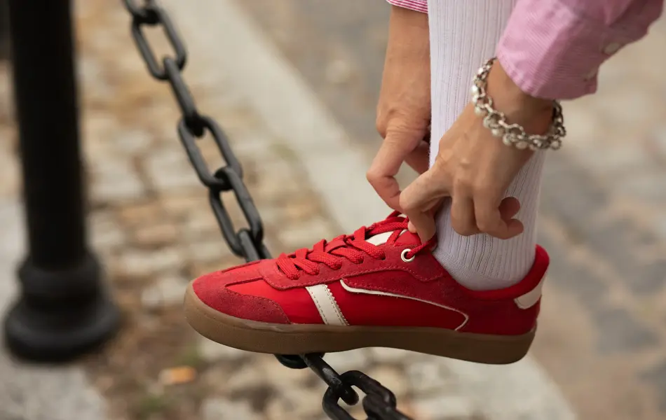 Nærbilde av damehender som knyter lisser på røde joggesko 