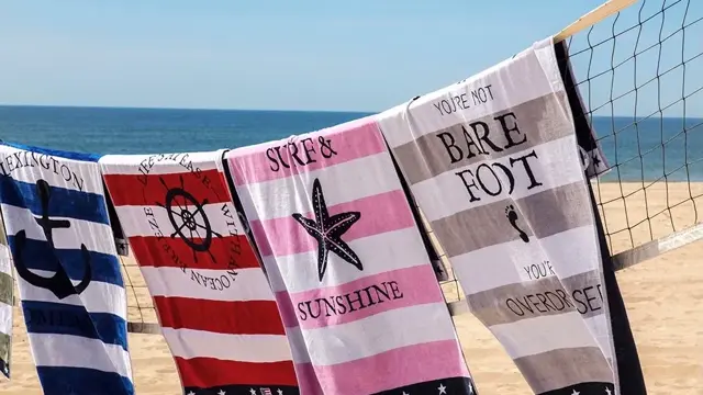 Fargerike badehåndklær som henger på et nett