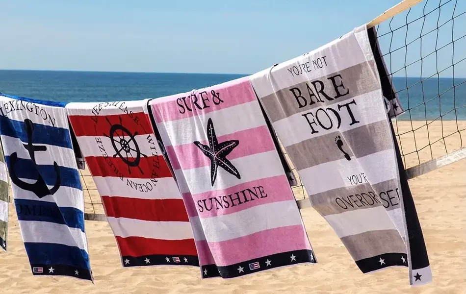 Fargerike badehåndklær som henger på et nett