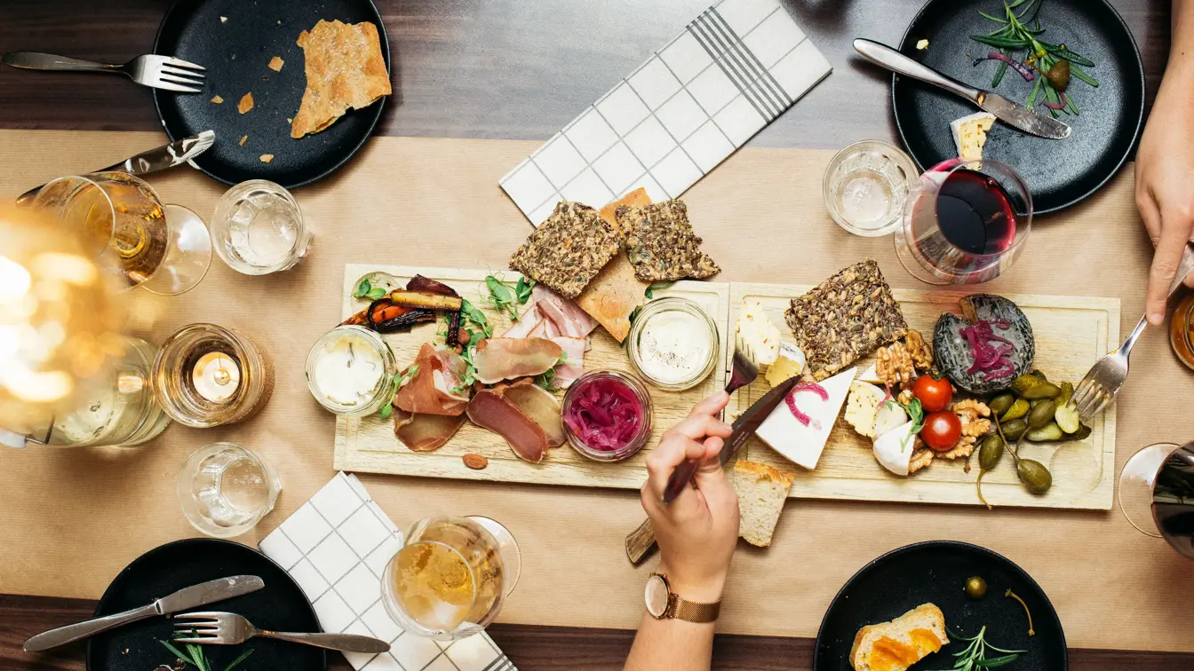 Lyst spisebord dekket med servise og tapasmat. 